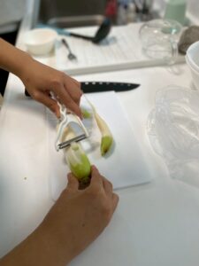 ピーラーで大根の皮を剥く